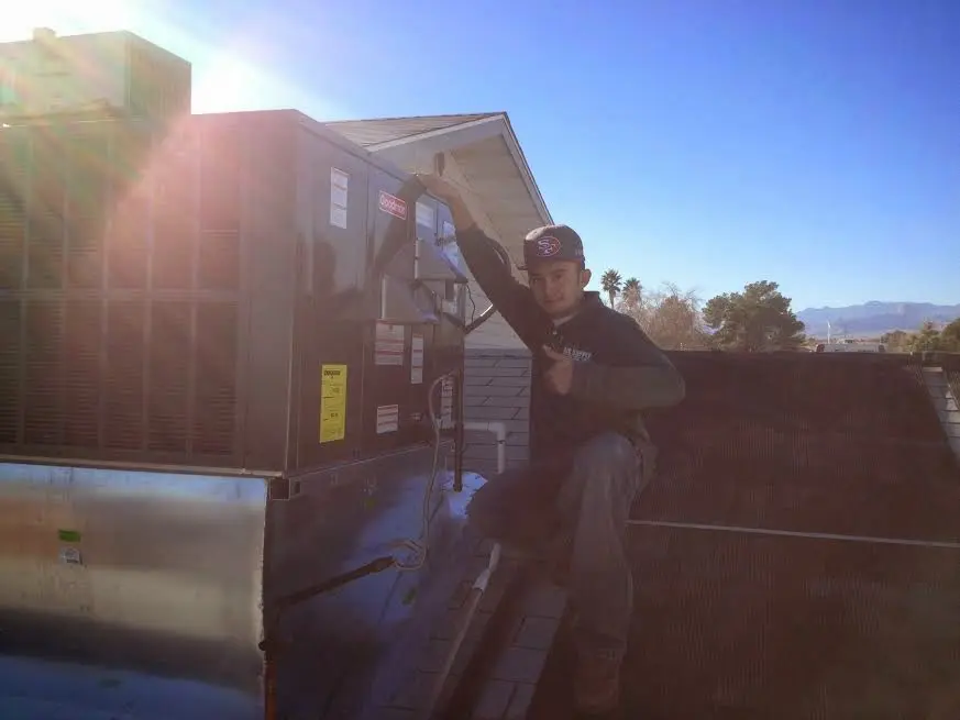 HVAC technician performing AC Tune-Up on a rooftop unit in Richardson